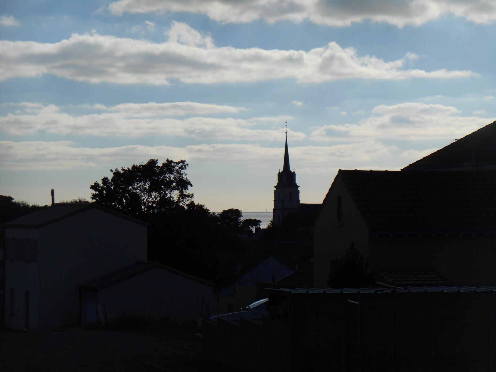 La vue contrastée avec la mer lumineuse et l'église sombre (Les Moutiers en Retz)